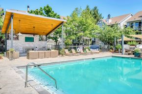 Hillsboro apartment for rent - A swimming pool with a glass enclosure and a yellow roofed pavilion.