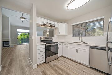 Sacramento apartment for rent - A modern kitchen with white cabinets and wooden floors.