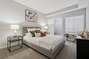 Foothill Ranch apartment for rent - A bedroom with a large bed, a nightstand with a lit candle, and a painting on the wall.