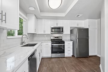 Alta Loma apartment for rent - A modern kitchen with white cabinets and stainless steel appliances.