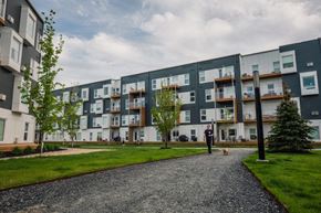 Winnipeg apartment for rent - a man walking his dog in front of an apartment building