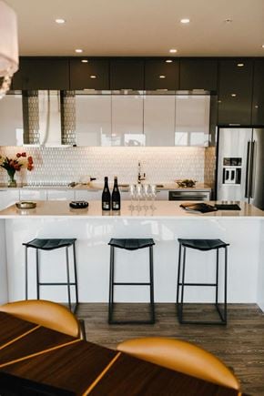 Winnipeg apartment for rent - a white kitchen with bar stools and counter tops