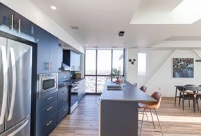 Winnipeg apartment for rent - a large kitchen with blue cabinets and a table and chairs