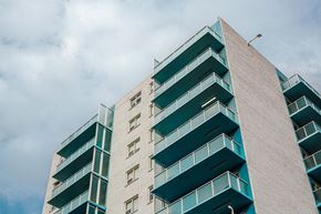 Winnipeg apartment for rent - a tall building with balconies and a cloudy sky