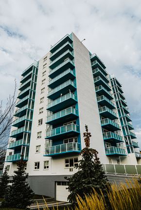 Winnipeg apartment for rent - a tall building with green windows and a cloudy sky