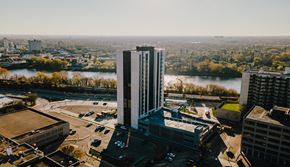 Winnipeg apartment for rent - an aerial view of a tall building with a river in the background