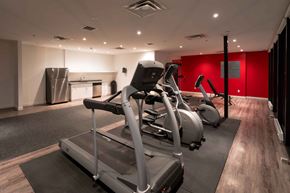 Winnipeg apartment for rent - a gym with exercise equipment and a red wall