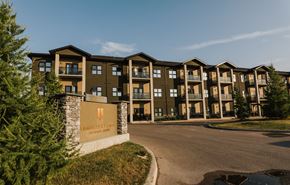 Winnipeg apartment for rent - an apartment building with a sign and trees in the foreground