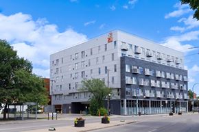 Winnipeg apartment for rent - A large white building with a red logo on the top left corner.