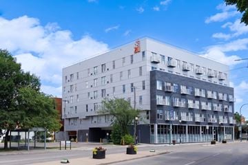 Winnipeg apartment for rent - A large white building with a red logo on the top left corner.