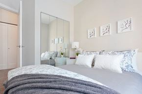 Winnipeg apartment for rent - a white bedroom with a bed and a mirror