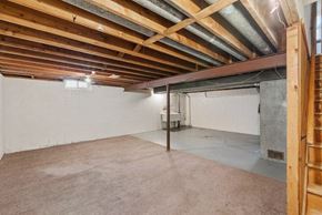 Wauwatosa apartment for rent - the basement of a building with a concrete floor and exposed wooden beams