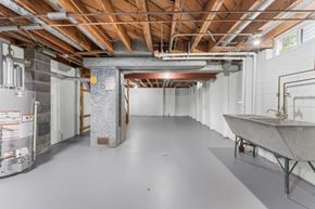 Milwaukee triplex for rent - A spacious unfinished room with a concrete floor and exposed ceiling structure.