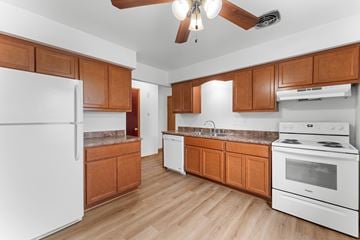 Milwaukee triplex for rent - A kitchen with wooden cabinets and white appliances.
