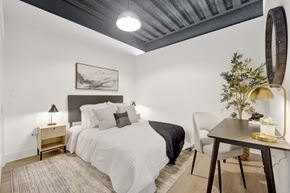 Chicago apartment for rent - A bedroom with a bed, a chair, a table, and a painting on the wall.
