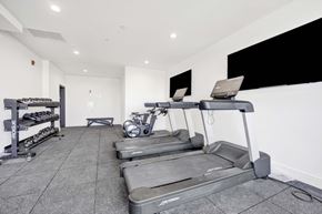 Chicago apartment for rent - A gym with treadmills, weights, and a bench.