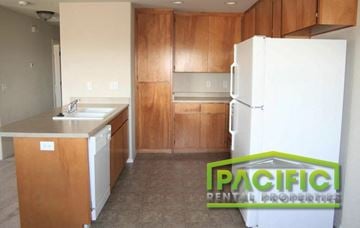 Medford apartment for rent - a kitchen with wooden cabinets and a white refrigerator