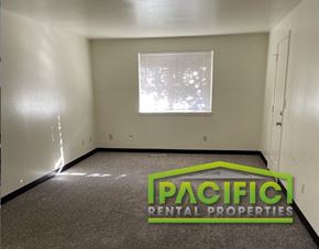 Medford apartment for rent - an empty room with a pacific rental properties logo on the floor