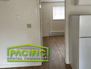 Ashland apartment for rent - an empty kitchen with a refrigerator and a door