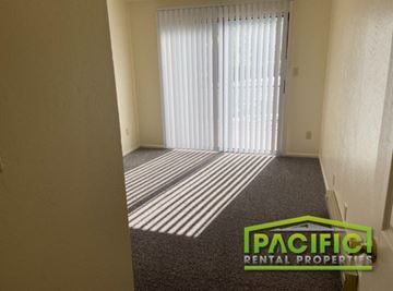 Ashland apartment for rent - a living room with a window and a carpet and a pacific rental properties logo