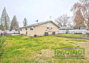 Eagle Point apartment for rent - A house with a lawn in front of it and trees in the background.