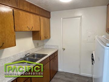 Ashland apartment for rent - a kitchen with wooden cabinets and a sink and a refrigerator
