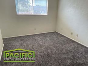 Ashland apartment for rent - a carpeted room with a window and pacific rental properties logo on the floor