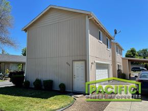 Medford apartment for rent - a white building with a white garage and a green yard sign