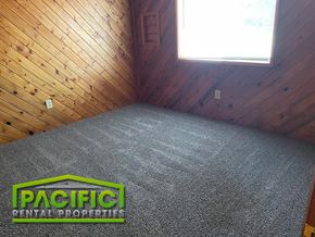 Medford apartment for rent - the inside of a small room with carpet and a logo on the floor