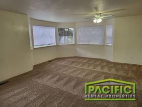 Medford apartment for rent - an empty living room with a ceiling fan and three windows