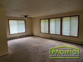 Medford apartment for rent - an empty living room with a ceiling fan and three windows