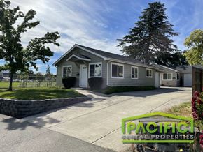 Medford apartment for rent - a small gray house with a driveway and a tree