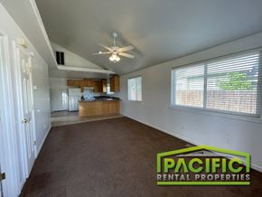 Medford apartment for rent - an empty living room with a ceiling fan and a kitchen