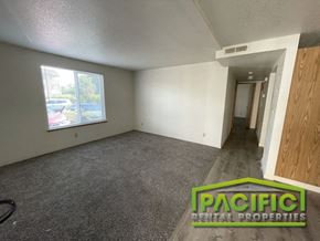 Medford apartment for rent - an empty living room with gray carpet and a window