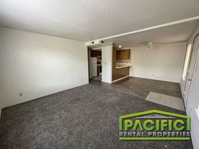 Medford apartment for rent - an empty living room with carpet and a kitchen