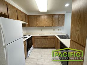 Medford apartment for rent - a kitchen with wooden cabinets and white appliances and a refrigerator