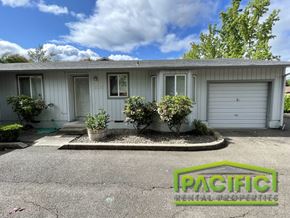 Medford apartment for rent - a small gray house with three bushes in front of it