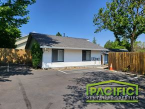 Ashland apartment for rent - a small white house in a parking lot with a fence