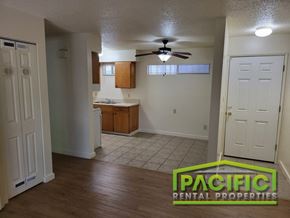 Ashland apartment for rent - an empty living room and kitchen with a ceiling fan