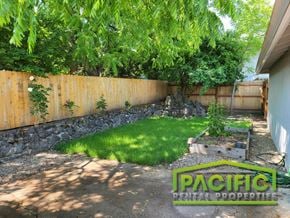 Ashland apartment for rent - a backyard with a wooden fence and a lawn with grass