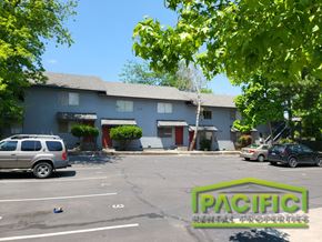 Ashland apartment for rent - a parking lot in front of a blue building with cars parked