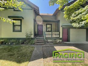 Ashland apartment for rent - front view of a green house with a porch and a front lawn