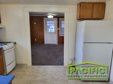 Ashland apartment for rent - a kitchen with a white refrigerator and a door into a house