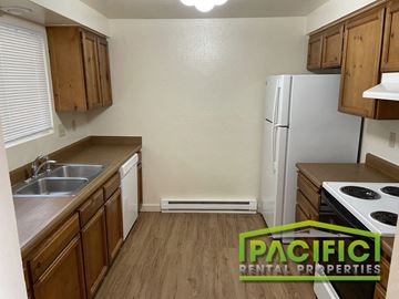 Ashland apartment for rent - a kitchen with wooden cabinets and a sink and a refrigerator