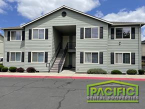 Medford apartment for rent - a grey apartment building with a pacific rental properties sign in front