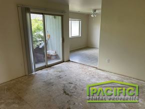 Medford apartment for rent - an empty living room with a sliding glass door to a patio