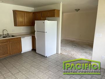 Medford apartment for rent - an empty kitchen with a white refrigerator and wooden cabinets