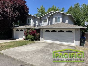 Eagle Point apartment for rent - A house with a garage and a tree in front of it.