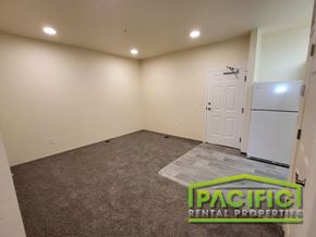 Medford apartment for rent - an empty room with a refrigerator and a door