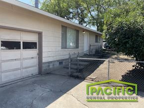 Ashland apartment for rent - a white house with two garage doors and a chain link fence